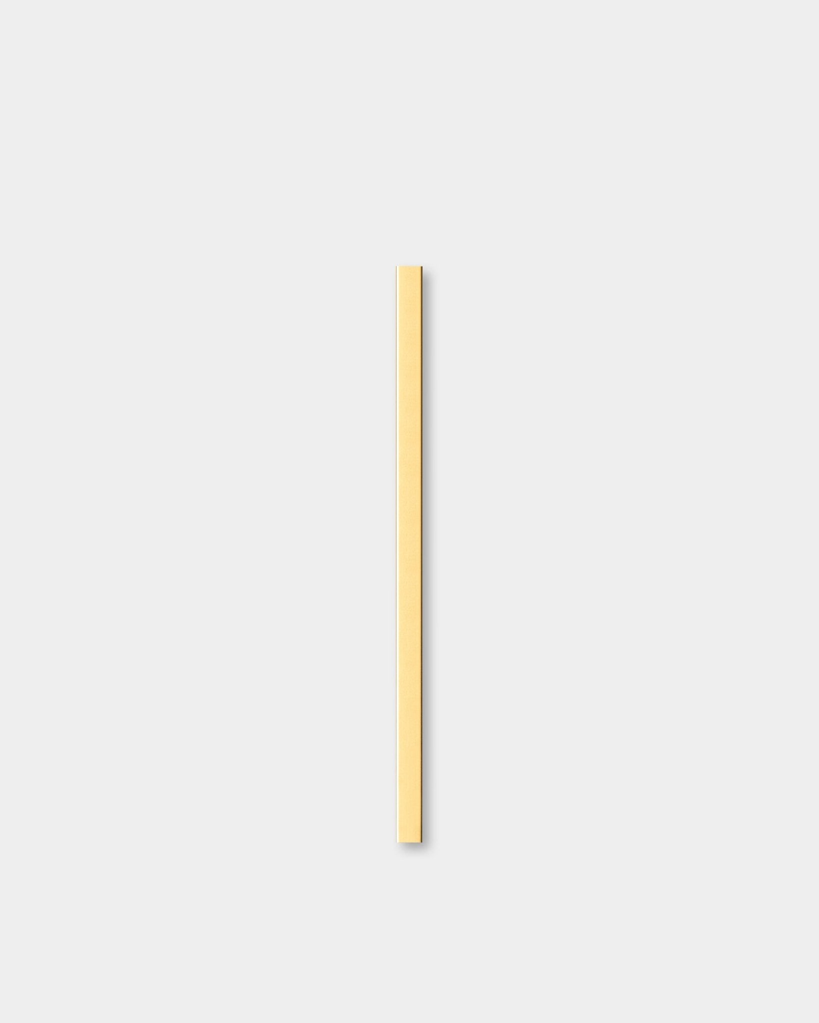 Liva | Cover i brass, 60 cm från WoodUpp, en Akustikpanel, står vertikalt mot en ljusgrå bakgrund intill dekorativ vägglist.